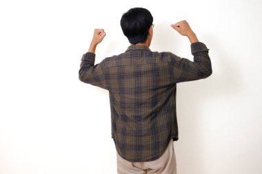 Asyalı genç bir adamın kollarını kaldırıp izole edilmiş beyaz arka plandaki başarısını kutlaması.