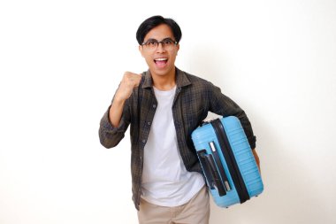 Git hadi! Heyecanlı Asyalı genç bir adam bavulu tutuyor ve beyaz arka planda koşan bir jest yapıyor.