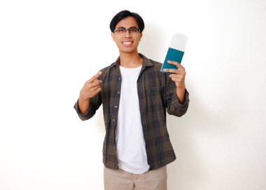 Asyalı turist, elinde pasaportu ve biniş kartıyla gülümsüyor, seyahat etmeye hazır, beyaz bir arka planda tek başına.