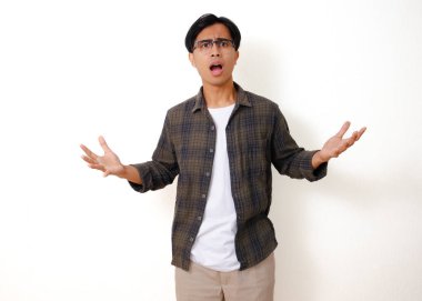 Genç Asyalı adam beyaz arka planda izole edilmiş, şok olmuş yüz ifadesiyle kameraya bakıyor.