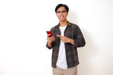Beyaz bir arka planda izole edilmiş cep telefonu kullanan kendine güvenen genç Asyalı adam.