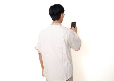 Beyaz arka planda izole edilmiş akıllı bir telefon tutan Endonezyalı Müslüman adam.