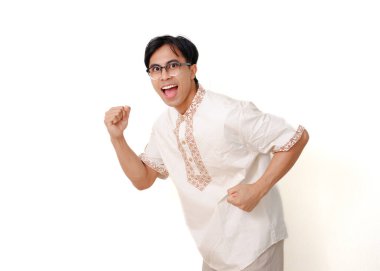 Heyecanlı Endonezyalı Müslüman, beyaz bir arka planda izole edilmiş, koşan bir jestle poz veriyor.