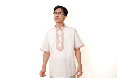 Sakin Endonezyalı Müslüman adam gözleri kapalı ve barışçıl bir ifadeyle beyaz arka planda duruyor.