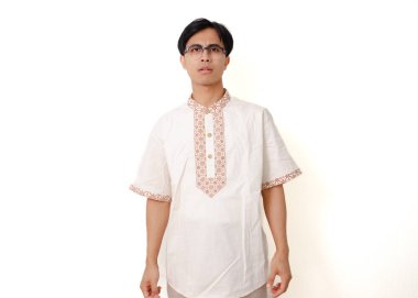 Endonezyalı Müslüman adam dikilip kameraya tarafsız bir ifadeyle bakıyor, temiz beyaz arka planda izole edilmiş.