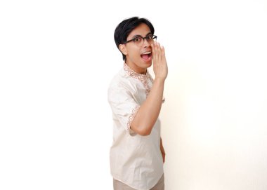 Heyecanlı Endonezyalı Müslüman adam beyaz arka planda izole edilmiş bağırıyor ve jestler yapıyor.