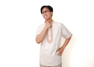 Sağlıksız Endonezyalı Müslüman adam boğazına acı dolu bir ifadeyle dokunuyor, beyaz arka planda izole edilmiş.