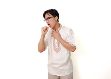 Sağlıksız Endonezyalı Müslüman adam boğazına dokunuyor ve öksürüyor.