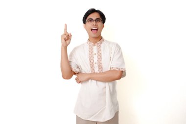 Mutlu, beyaz arka planda duran Endonezyalı Müslüman adam, düşünceli bir jest yaparak, fikrini ifade ederek,