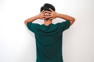 Stresli Asyalı adam kafasını arkadan tutuyor. İzole edilmiş beyaz arka planda hayal kırıklığı ve endişe gösteriyor. Duygusal bakış açısı.