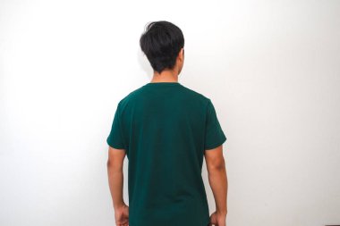 Yeşil tişört giyen Asyalı genç bir adamın beyaz arka planda dikilirken görüntüsü. Reklamlar ve pazarlama için mükemmel..