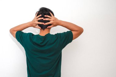 Stresli Asyalı adam kafasını arkadan tutuyor. İzole edilmiş beyaz arka planda hayal kırıklığı ve endişe gösteriyor. Duygusal bakış açısı.