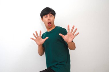 Yüzünde komik bir ifadeyle şok olmuş ve şaşırmış genç bir Asyalı adam beyaz arka planda izole edilmiş, reklam, tepki veya duygu konsepti için mükemmel.