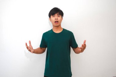 Asyalı genç bir adamın portresi. Kafası karışmış bir yüz ifadesiyle kameraya bakıyor. Sade bir arkaplanda izole edilmiş.