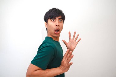 Şaşırmış ve hayal kırıklığına uğramış Asyalı genç bir adam geniş gözlü ve ağzı açık komik bir yüz yapıyor, beyaz arka planda izole edilmiş, tepki, duygu veya reklam kavramları için mükemmel.