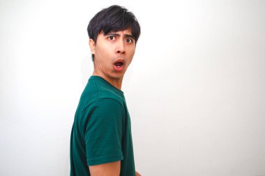 Şaşırmış ve hayal kırıklığına uğramış Asyalı genç bir adam geniş gözlü ve ağzı açık komik bir yüz yapıyor, beyaz arka planda izole edilmiş, tepki, duygu veya reklam kavramları için mükemmel.