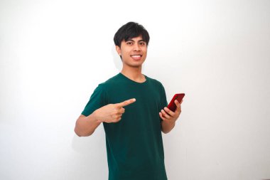 Akıllı telefonu tutan gülümseyen Asyalı genç adam, ekranda dikilirken, izole beyaz arka planda duruyor. Reklam, teknoloji veya yaşam tarzı içeriği için mükemmel