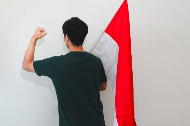 Bağımsızlık gününü kutlamak için elinde bayrak tutan heyecanlı Endonezyalı adamın beyaz arka planda duruşu vatanseverlik olayları ve reklamlar için mükemmel..