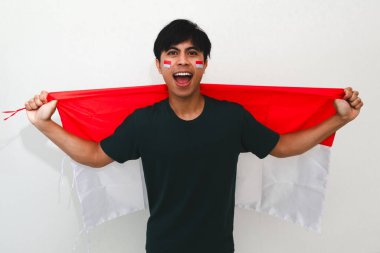 Heyecanlı Endonezyalı adam bayrak tutuyor ve sevinçle bağırıyor. Beyazların izole edilmiş arka planında başarıyı kutluyor. Bağımsızlık günü, zafer ve reklam temaları için mükemmel..