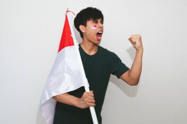 Heyecanlı genç Asyalı erkekler Endonezya 'nın bağımsızlık gününü 17 Ağustos' ta beyaz arka planda izole edilmiş Endonezya bayrağını tutarak kutladılar.