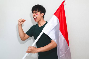 Heyecanlı genç Asyalı erkekler Endonezya 'nın bağımsızlık gününü 17 Ağustos' ta beyaz arka planda izole edilmiş Endonezya bayrağını tutarak kutladılar.