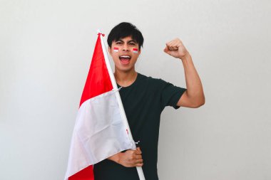 Heyecanlı genç Asyalı erkekler Endonezya 'nın bağımsızlık gününü 17 Ağustos' ta beyaz arka planda izole edilmiş Endonezya bayrağını tutarak kutladılar.
