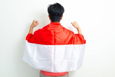 Endonezyalı genç bir adamın Endonezya bayrağını tutarken zafer pozuyla bağımsızlığını kutlaması