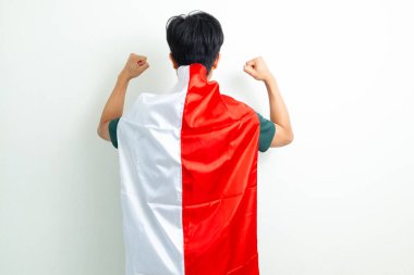 Endonezyalı genç bir adamın Endonezya bayrağını tutarken zafer pozuyla bağımsızlığını kutlaması