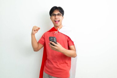 Endonezyalı heyecanlı adam 17 Ağustos 'ta bağımsızlığını kutluyor. Elinde Endonezya bayrağı ve akıllı telefonu var.