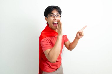 Ulusal bayrağı tutan Endonezyalı genç bir adam, kenarı işaret ederken bir jest yapıyor, beyaz üzerine izole edilmiş.