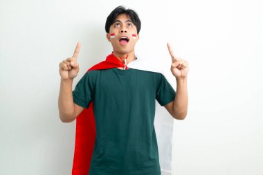 Endonezyalı genç bir adam gururla gülümseyerek Endonezya bayrağını tutuyor ve 17 Ağustos 'ta bağımsızlığını kutluyor.