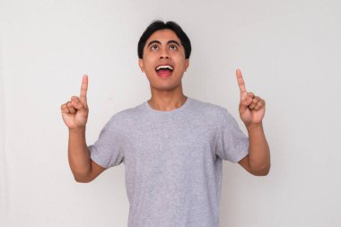 Heyecanlı genç Asyalı adam iki eliyle boş fotokopi alanını işaret ediyor, beyaz arka planda izole edilmiş. Reklamlar, promosyonlar ya da iş sunumları için mükemmel.