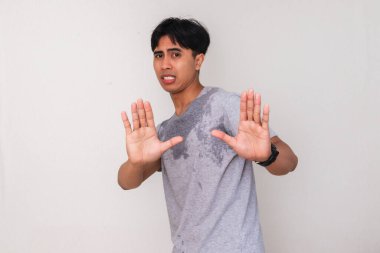 Beyaz arka planda izole bir şekilde el hareketi yapan terli bir Asyalı adamın portresi. Sağlık, farkındalık, protesto ya da duygusal ifade kampanyaları için mükemmel