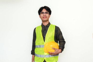 İzole bir arkaplanda duran gülümseyen, kendinden emin Asyalı genç bir mühendisin portresi. Reklam ve profesyonel temalar için ideal