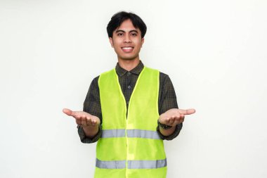 Mutlu Asyalı inşaat işçisi beyaz arka planda izole edilmiş neşeli bir ifadeyle kameraya iki avuç içini de gösteriyor.