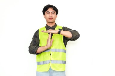 Asyalı inşaat işçisi, beyaz arka planda izole edilmiş, iki eliyle hareket yapıyor. Reklam kullanımında stres, duraklama veya işyeri iletişim kavramları için mükemmel