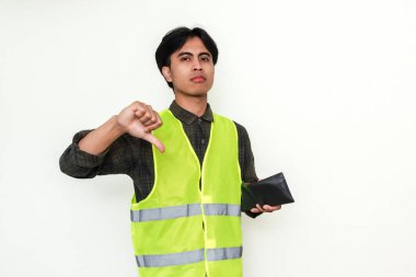 Asyalı inşaat işçisi elinde cüzdan tutarken parmaklarını gösteriyor. Finansal mücadeleyi ya da onaylanmamayı temsil eden güçlü bir görsel