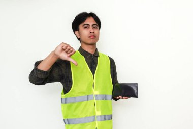 Asyalı inşaat işçisi elinde cüzdan tutarken parmaklarını gösteriyor. Finansal mücadeleyi ya da onaylanmamayı temsil eden güçlü bir görsel