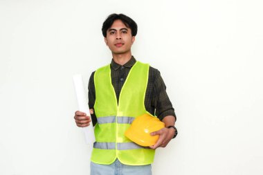 İzole bir arkaplanda duran gülümseyen, kendinden emin Asyalı genç bir mühendisin portresi. Reklam ve profesyonel temalar için ideal