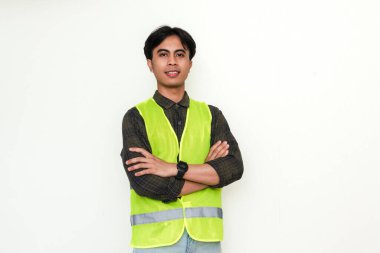 Asyalı kendine güvenen inşaat işçisi kollarını kavuşturup beyaz arka planda kameraya gülümsüyor. Endüstriyel, işçi ya da işe alım reklam temaları için mükemmel