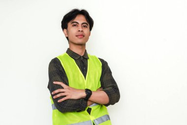 Asyalı kendine güvenen inşaat işçisi kollarını kavuşturup beyaz arka planda kameraya gülümsüyor. Endüstriyel, işçi ya da işe alım reklam temaları için mükemmel