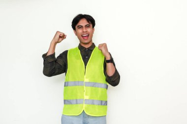 Heyecanlı Asyalı inşaat işçisi yumruklarını sıkarak başarıyı kutluyor. Beyaz arka plandaki portre, reklamlar, endüstri veya kariyer motivasyonu kavramları için mükemmel.