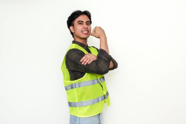 Kendine güvenen Asyalı inşaat işçisi kol kaslarını esnetiyor ve beyaz arka planda izole edilmiş güç gösterisi yapıyor.