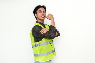 Kendine güvenen Asyalı inşaat işçisi kol kaslarını esnetiyor ve beyaz arka planda izole edilmiş güç gösterisi yapıyor.