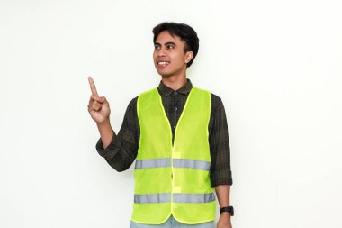 Kendine güvenen Asyalı inşaat işçisi beyaz arka planda yanlamasına işaret ediyor.