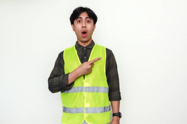 Asyalı bir inşaat işçisinin portresi, reklam ya da promosyon amaçlı beyaz arka planda izole edilmiş tuhaf bir ifadeyle yan tarafı işaret ediyor.