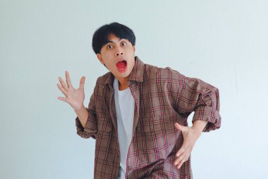 Şaşırmış Asyalı bir adam, şaşkın bir ifadeyle kameraya bakıyor, arka planda izole edilmiş, sürpriz veya tepki konsepti için mükemmel..