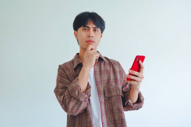 Asyalı bir adam ciddi düşünen bir yüze sahip, beyaz arka planda izole edilmiş, odaklanma ve konsantrasyon gösteriyor..