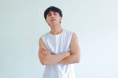 Spor kıyafetleri giymiş kızgın Asyalı bir adamın portresi ciddi yüz ifadeleri olan, beyaz arka planda izole edilmiş öfke, hüsran ve kararlılık kavramı.