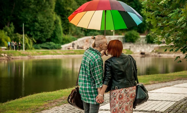 young couple of girls. Girls in love with lgbt umbrella. Two kissing girls Concept.